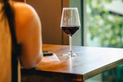 A glass of red wine on a table.