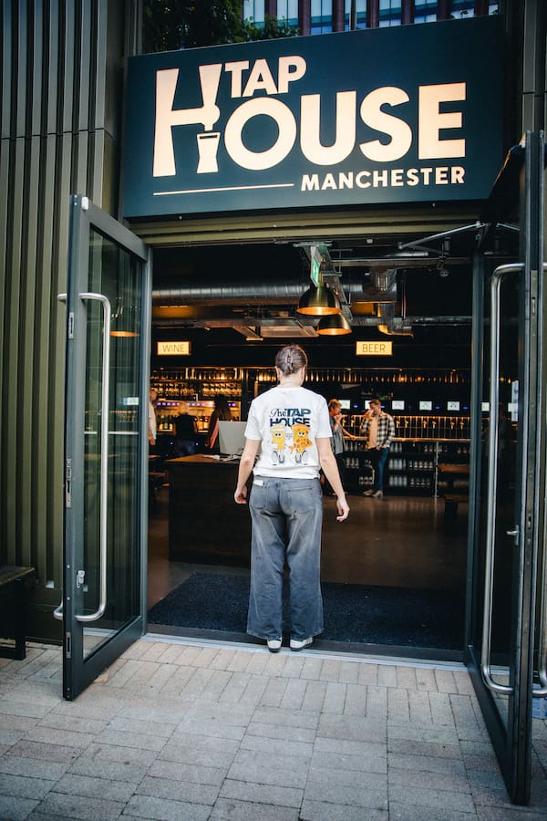 The front of The Tap House Manchester with a staff member stood out the front.