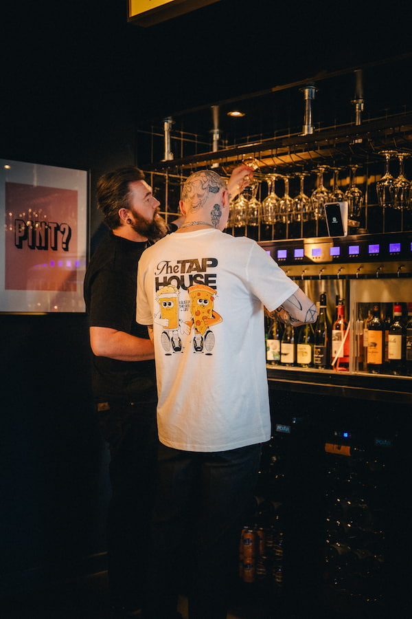 Two people using the self service wine facility.