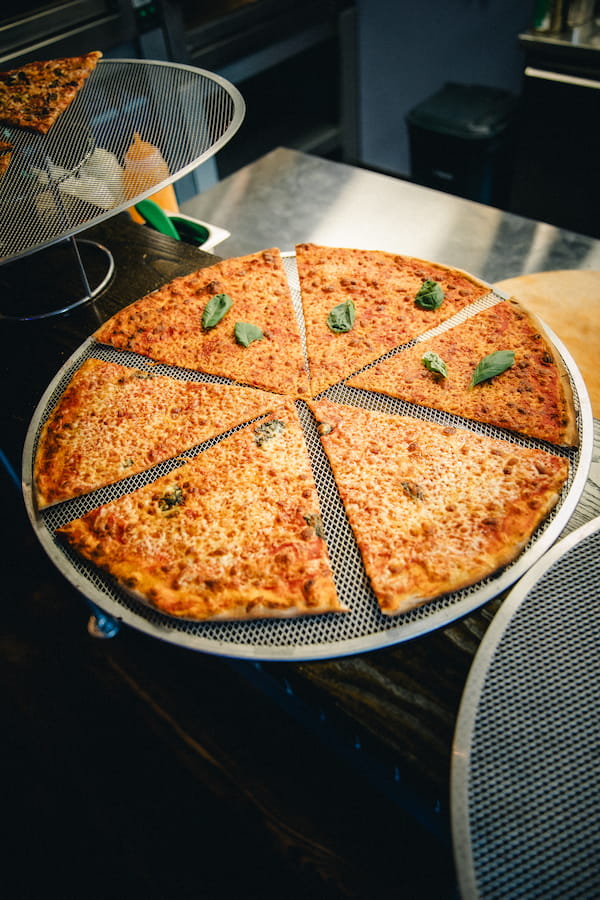 A pizza with fresh basil topping.