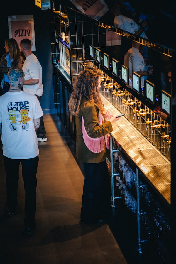 A person using the self service beer tap to pour themselves.