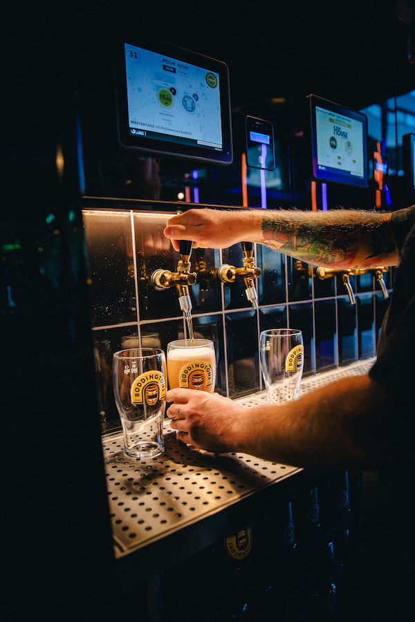 Using the self service beer taps to pour a drink.